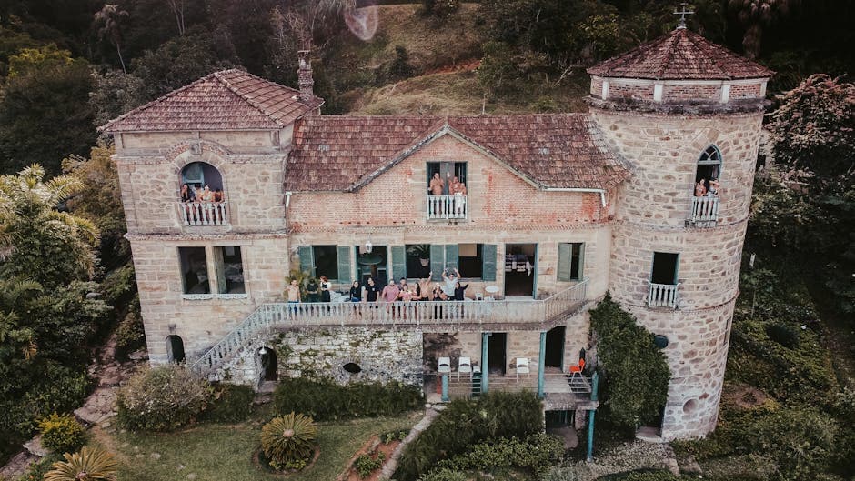 A beautiful aerial photo capturing a group of people on a balcony of a historical stone house in Brazil.