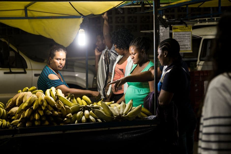 Group of people at a night market selling bananas in Brazil. Vibrant street life captured.
