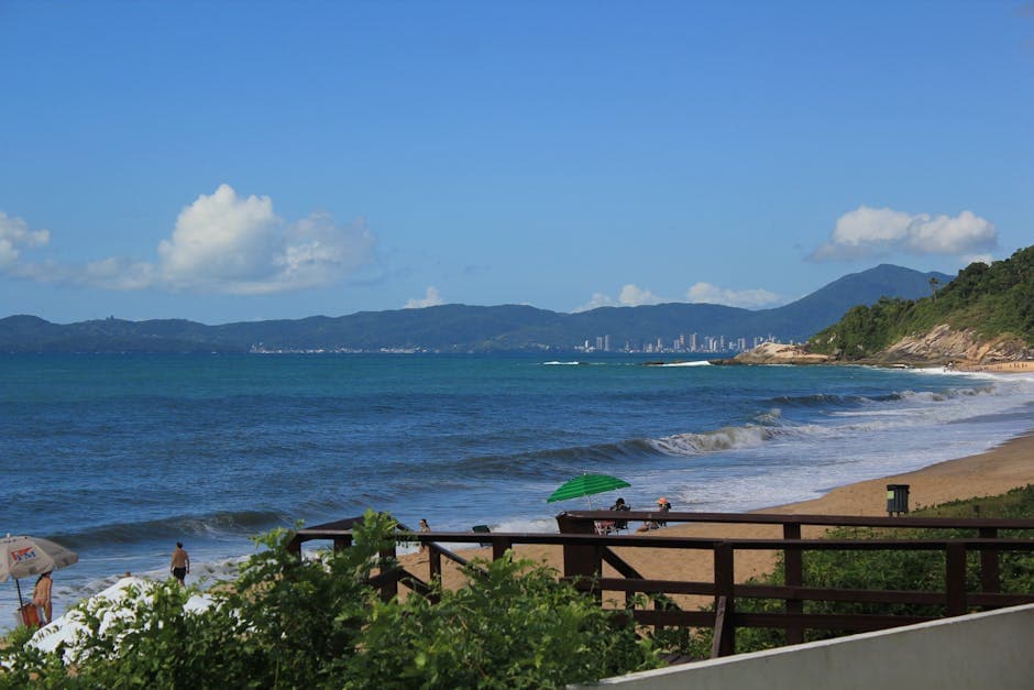 Beautiful beach scene with ocean waves and distant city skyline in Brazil.