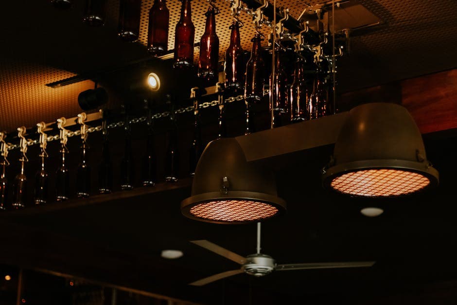 Industrial style ceiling lights and bottles create a moody ambiance in a São Paulo bar interior.