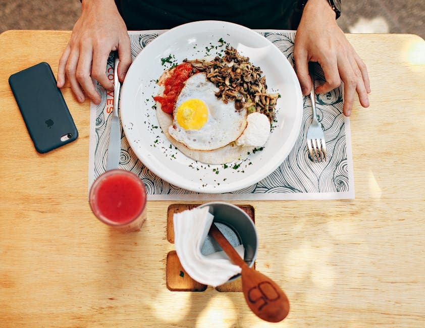 Tasty brunch with fried egg, mushrooms, tomatoes, and juice served indoors.