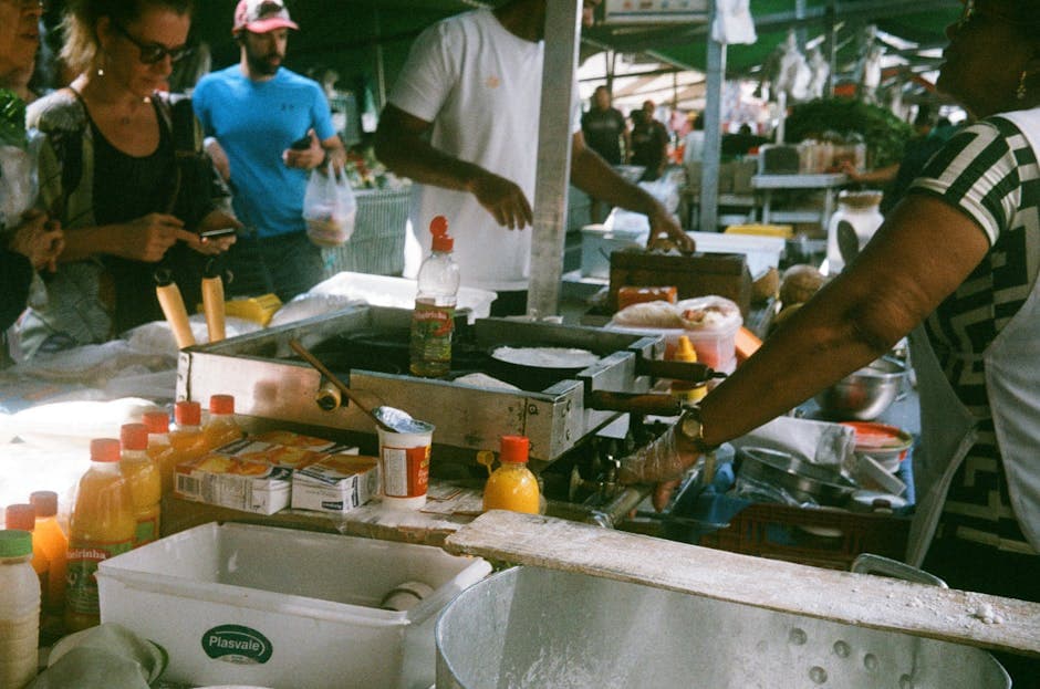 Bustling street food scene at a local market in São Paulo, Brazil with vendors and customers.