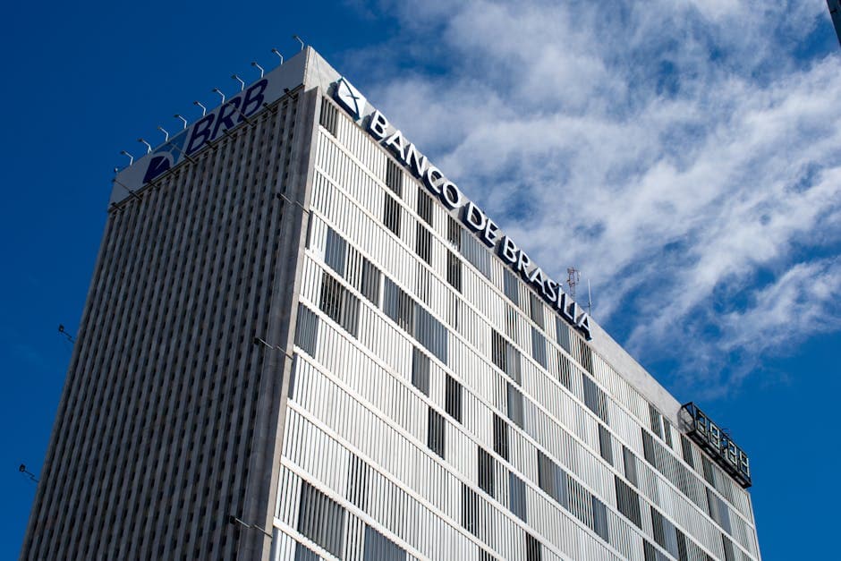 Skyward view of the Banco de Brasília, an iconic modern building in Brazil's capital, under a clear sky.