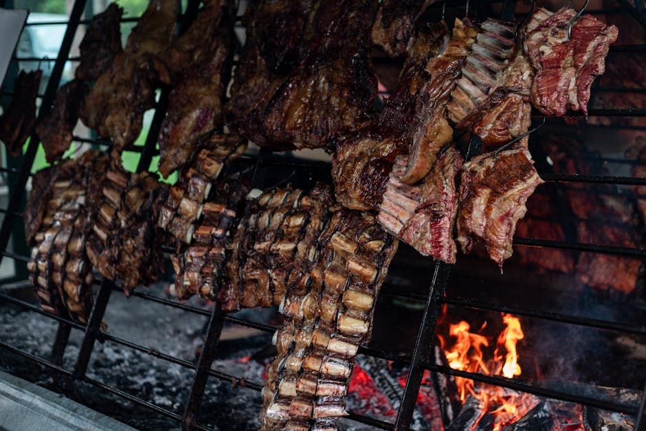 Traditional asado grilling with meat on a parrilla in Uribelarrea, Argentina.