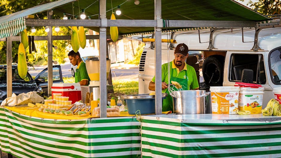 Street food stall with vendors preparing corn dishes in Campinas, Brazil.