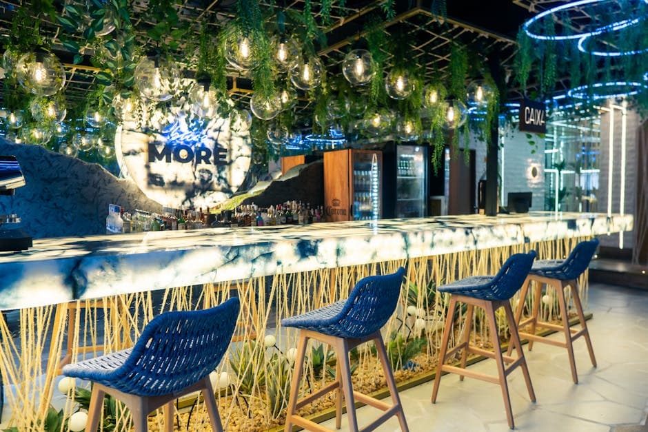 Contemporary bar interior in Rio de Janeiro with lush greenery and vibrant lighting.