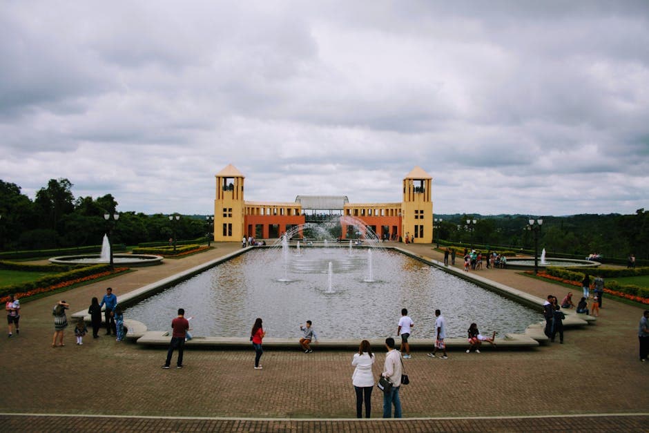 People enjoy a day at Curitiba's Wire Opera House with vibrant fountains and lush greenery.