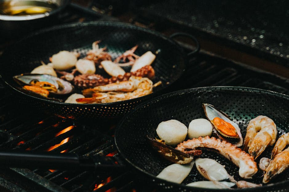 Close-up of a seafood medley grilling in a pan, featuring prawns, squid, and mussels. Perfect for cooking enthusiasts.