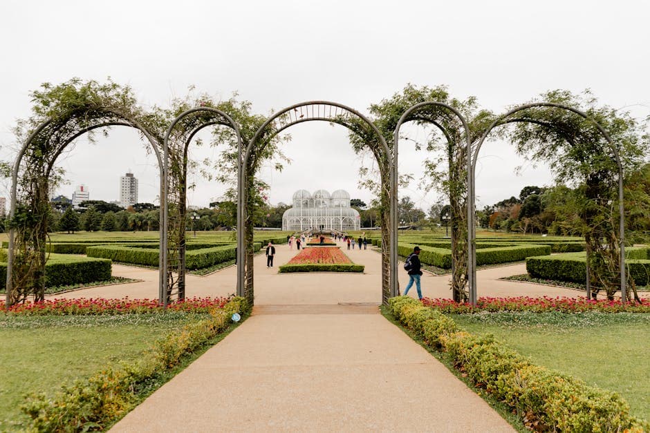 A scenic view of Curitiba's iconic botanical garden with lush greenery and elegant archway.
