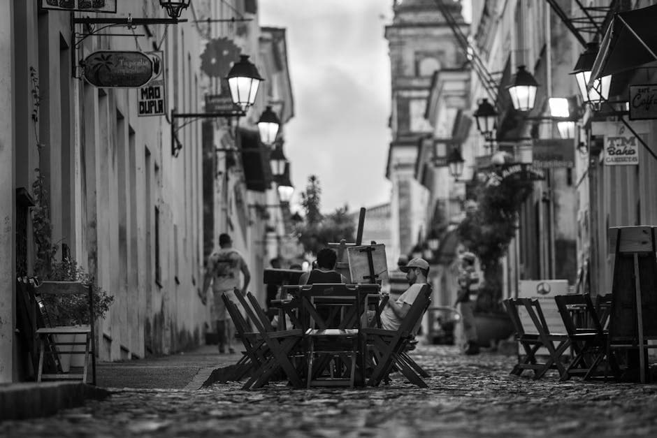 A monochrome street scene in Bahia, Brazil, featuring outdoor seating and atmospheric lighting.