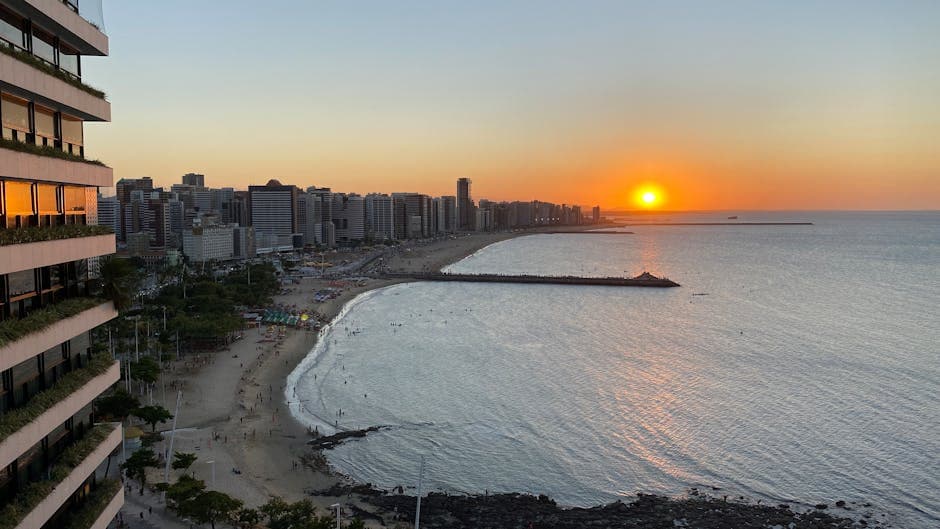 Breathtaking sunset view over a bustling city beach and oceanfront skyline.