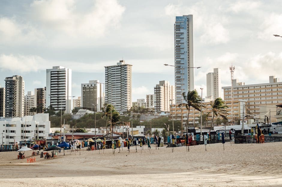 Skyline of Natal featuring skyscrapers and a vibrant beach scene with palm trees.