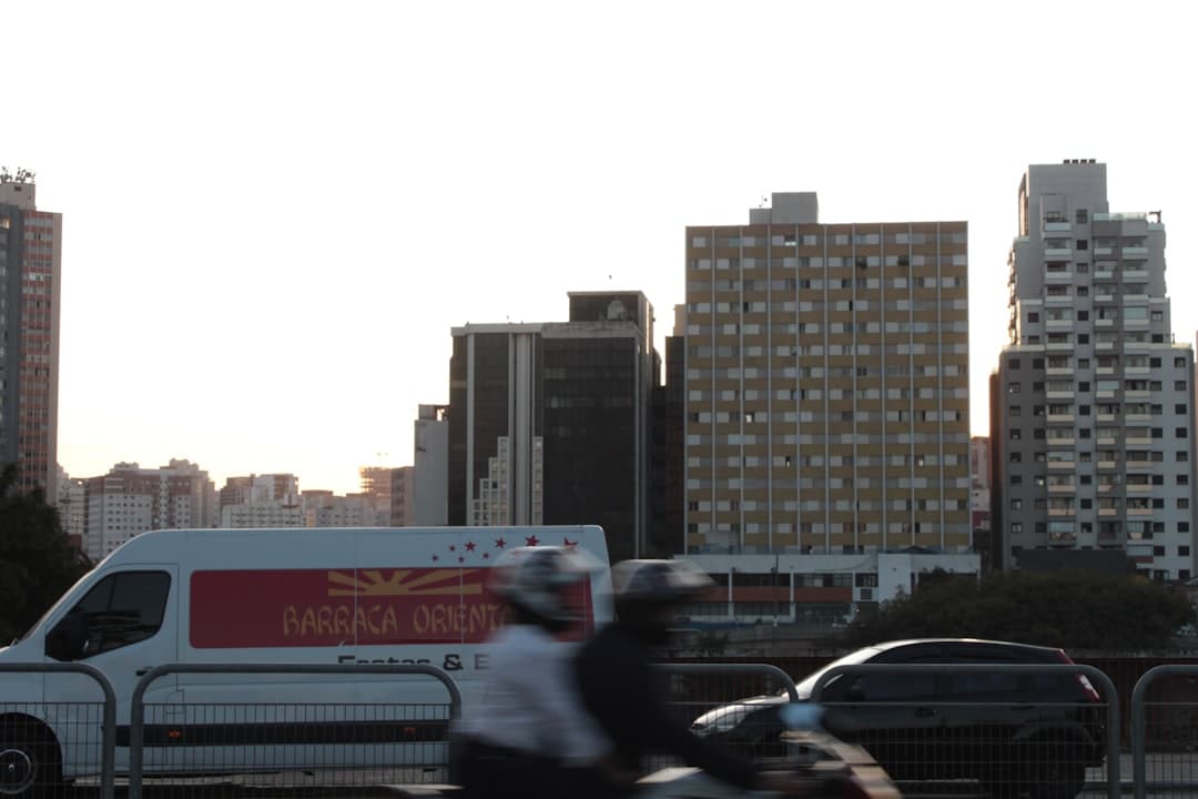 Blurred vehicles pass by a city skyline.