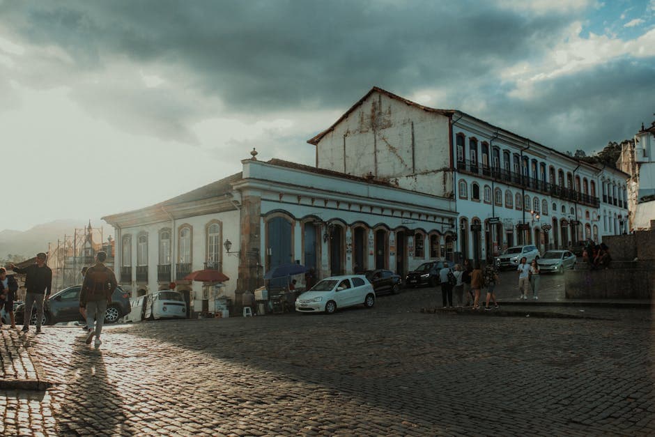 Sunlit historic town square with cobblestone streets and classic architecture.
