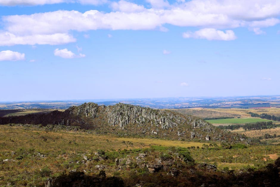 Expansive view of Morro do Cabeludo rock formation in Brazil's summer countryside.