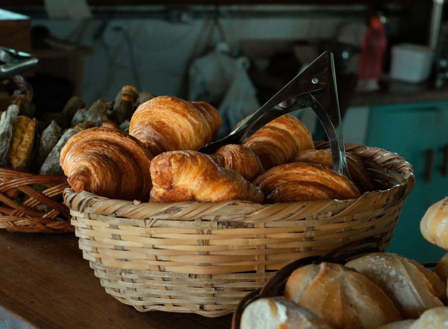 Basket of fresh croissants in a rustic bakery, capturing the essence of artisanal breadmaking.