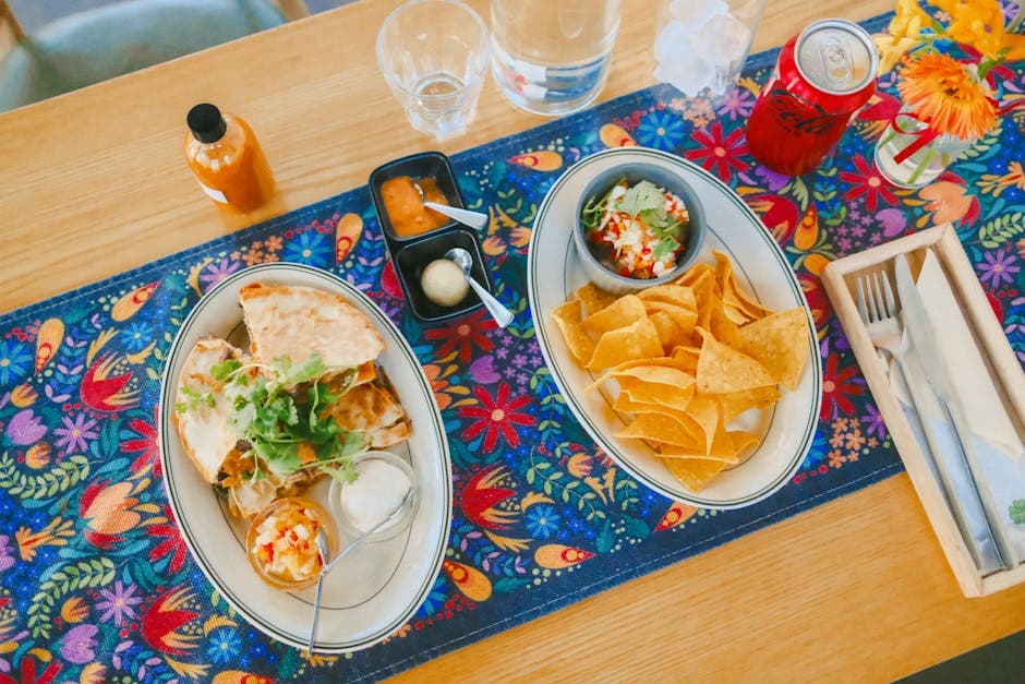 Vibrant Mexican meal with quesadillas, salsa, and nachos on a floral table setting.
