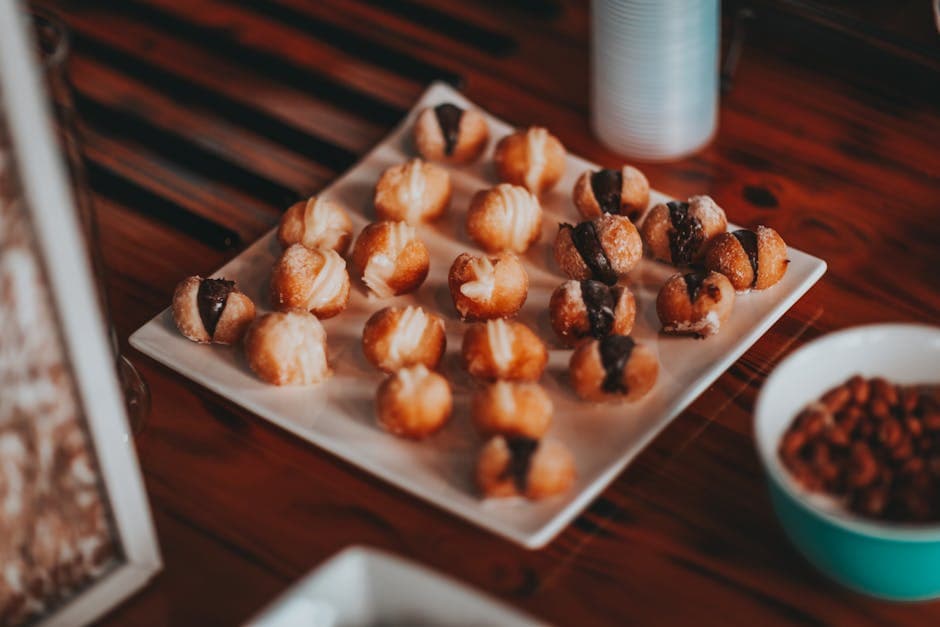 From above of delicious sweet creamy cookies served on white plate and placed on wooden table during breakfast in cafe