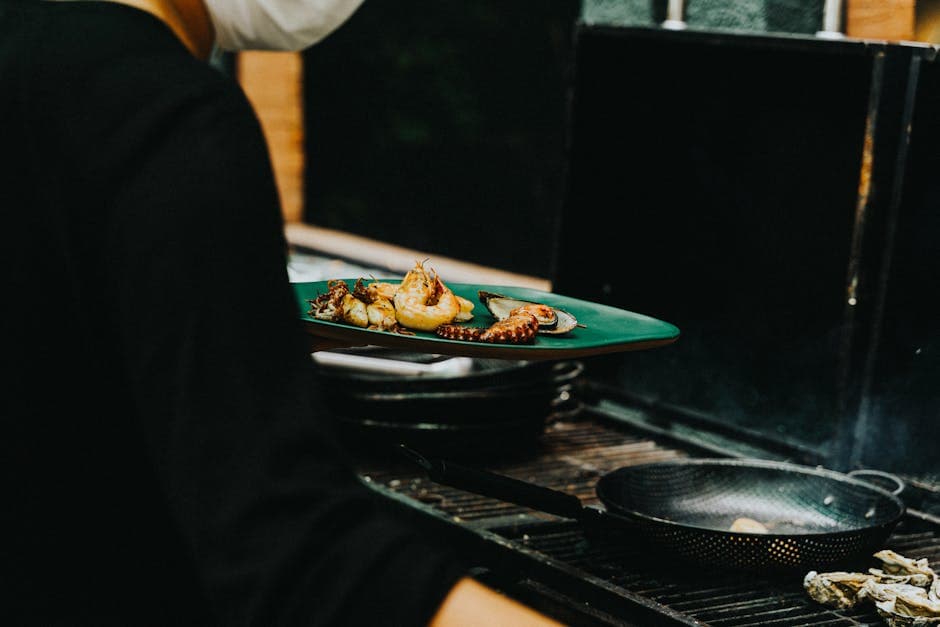 Chef preparing grilled seafood on a stove, featuring octopus and mussels. Indoor culinary scene.