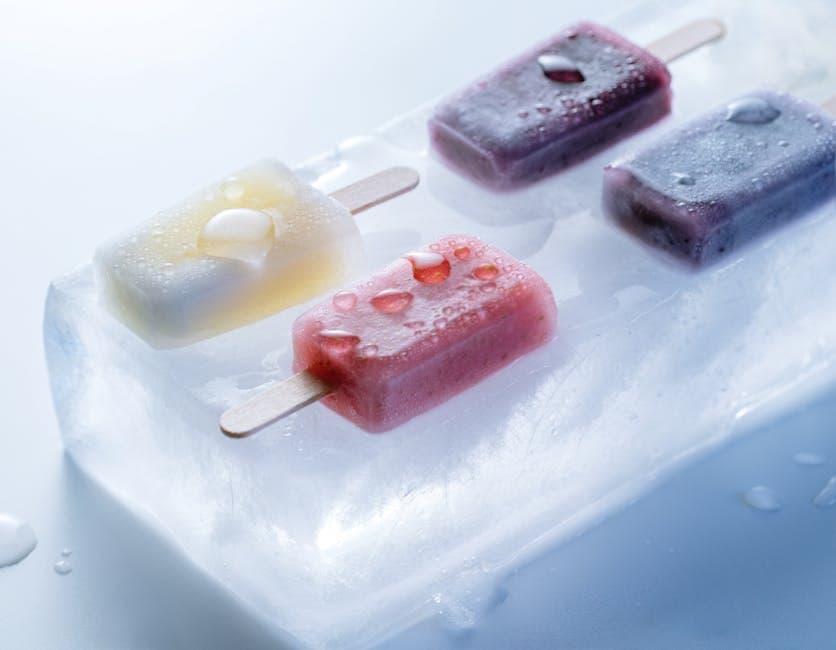 Delicious mixed fruit popsicles placed on a block of ice, perfect for summer refreshment.