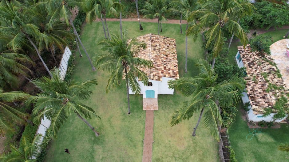 Aerial view of a tropical house surrounded by palm trees in Porto de Pedras, Alagoas, Brazil.