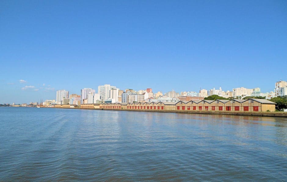 Panoramic view of Porto Alegre's skyline along the waterfront under a clear blue sky.