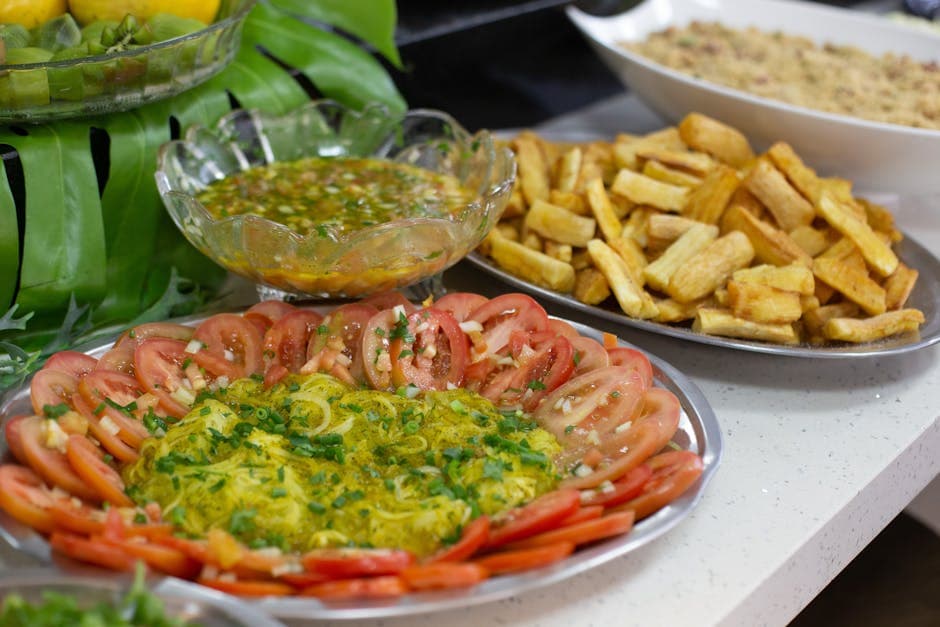 A vibrant display of traditional homemade dishes featuring fresh tomatoes, salad, and fried snacks.