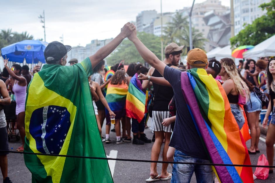 LGBT Pride Parade in Rio de Janeiro with people holding flags and celebrating solidarity.