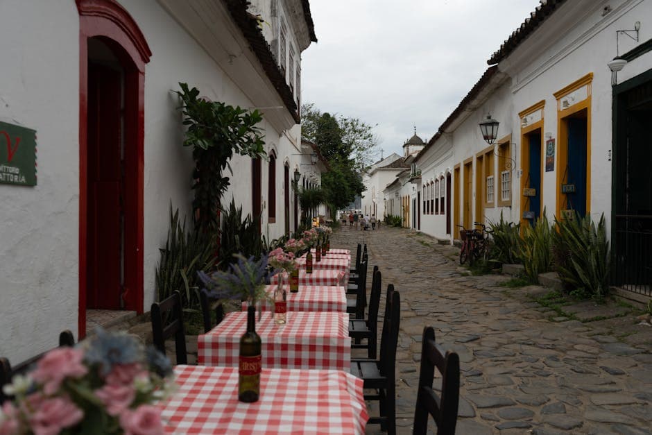 Picturesque street with tables in Paraty, Brazil, featuring colorful colonial architecture.