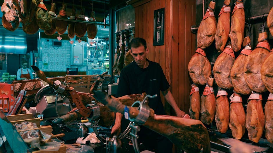 Man slicing Jamón in a traditional Barcelona market shop surrounded by hanging cured hams.