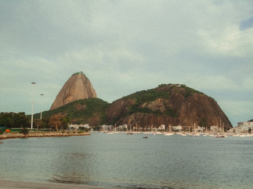 Explore the iconic Sugarloaf Mountain rising above the serene bay in Rio de Janeiro.