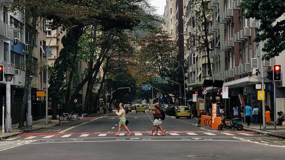 People crossing a street in Copacabana, Rio de Janeiro, surrounded by urban architecture.