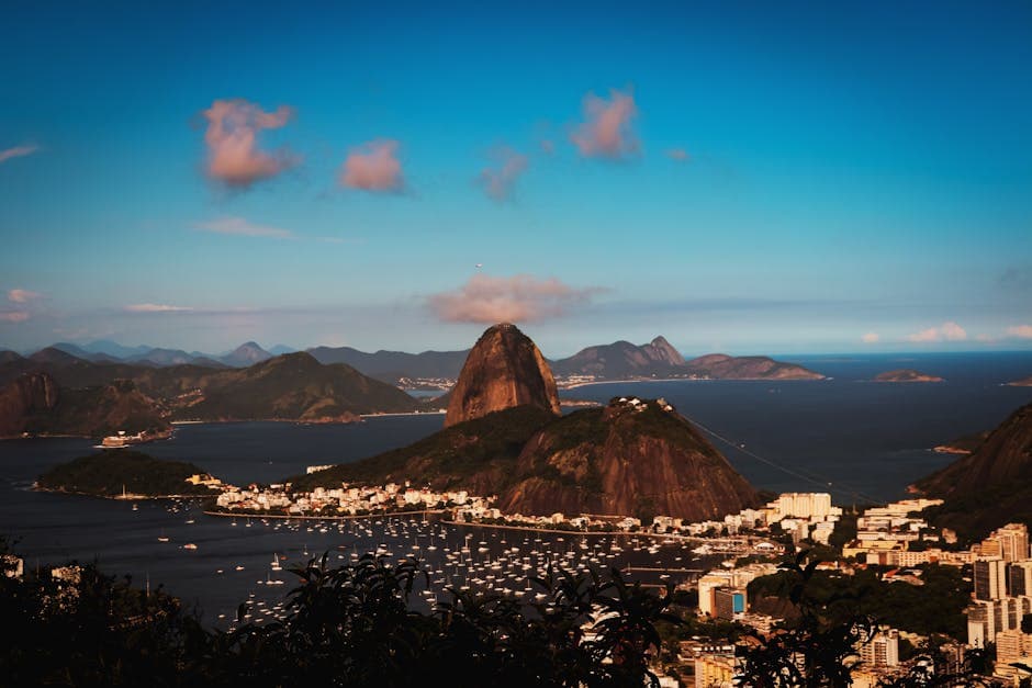 Experience the stunning beauty of Sugarloaf Mountain and Guanabara Bay in Rio de Janeiro during a vibrant day.