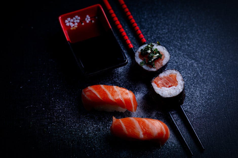 High-quality image of salmon nigiri and maki sushi with soy sauce and chopsticks.