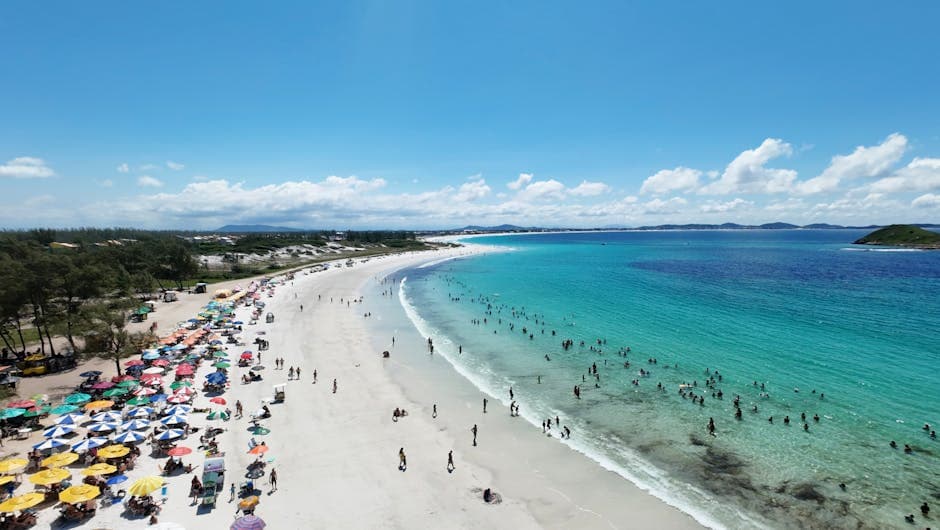 A stunning aerial view of a vibrant Brazilian beach filled with colorful umbrellas and bathers.