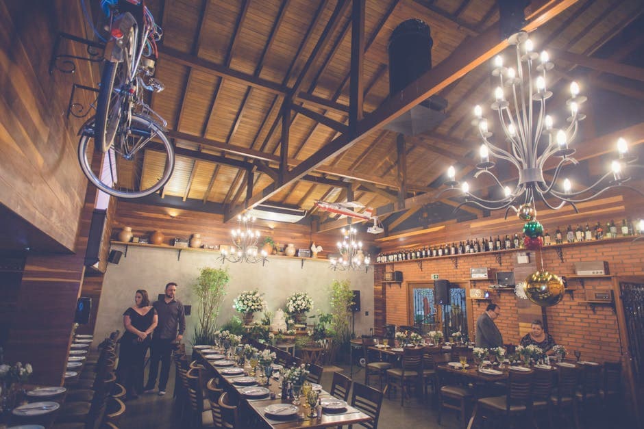 Charming rustic restaurant interior with elegant decor and long dining tables set for an event.