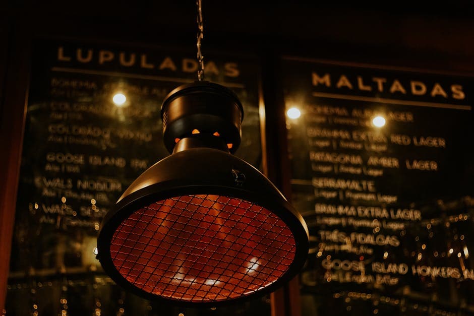 Close-up of a hanging light fixture in a cozy Brazilian pub setting with menu board in the background.