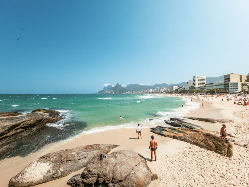 Enjoy a warm sunny day at Ipanema Beach with scenic views of Rio's coastline.