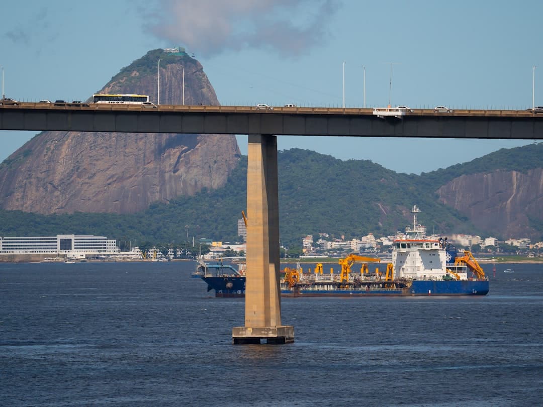 a bridge over a body of water with a mountain in the background