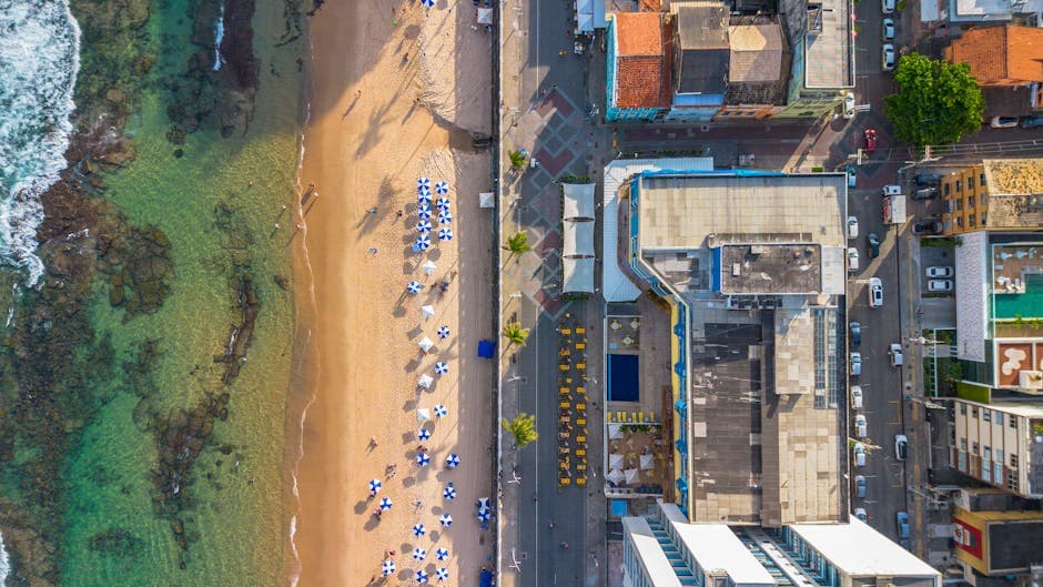 Stunning aerial view of Salvador's beachfront with umbrellas and nearby urban area.