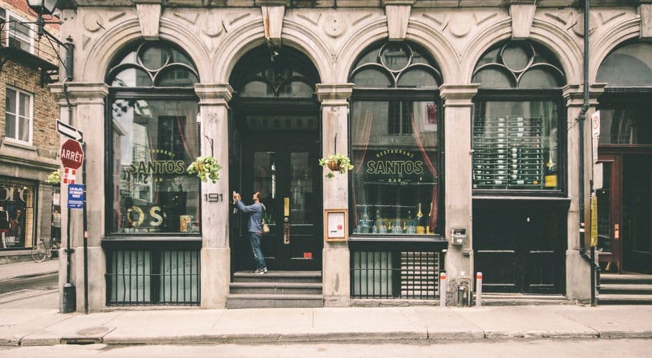 A historic restaurant facade with arched windows in a city street.