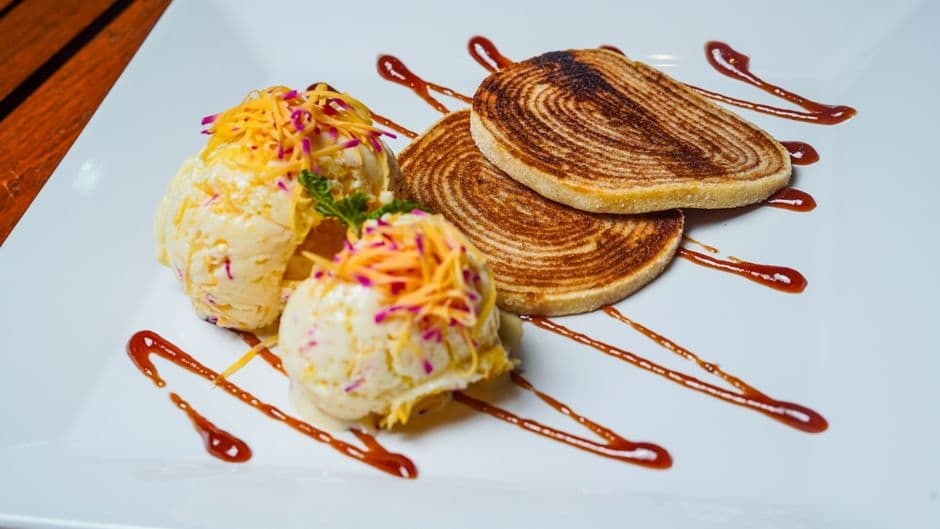 Delicious dessert featuring ice cream scoops with cookies, topped with colorful garnish.