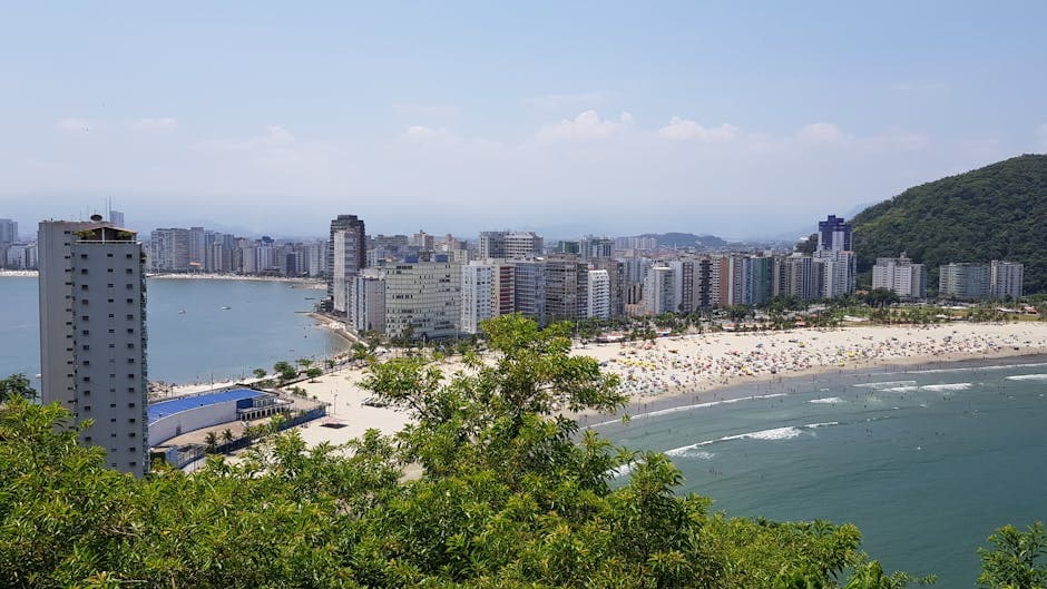 A vibrant cityscape with skyscrapers, beach, and ocean view on a sunny day.