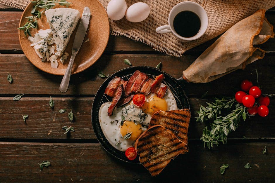 Delicious rustic breakfast spread with eggs, bacon, cheese, and toast on a wooden table.