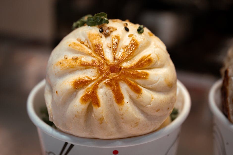 Delicious steamed bun topped with sesame seeds, perfect for a tasty snack.