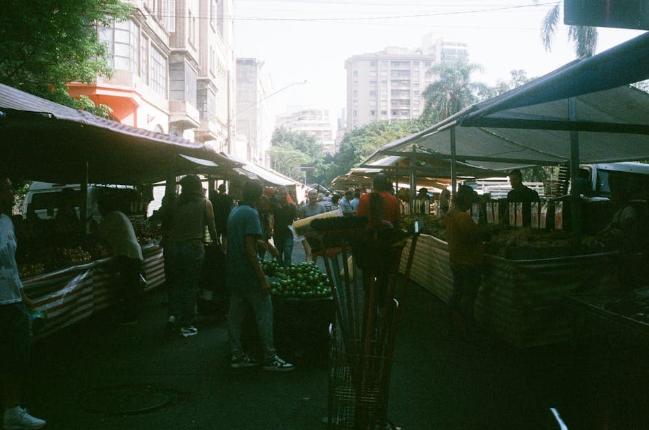 Lively street market scene in São Paulo, Brazil with fruit stands and bustling atmosphere.