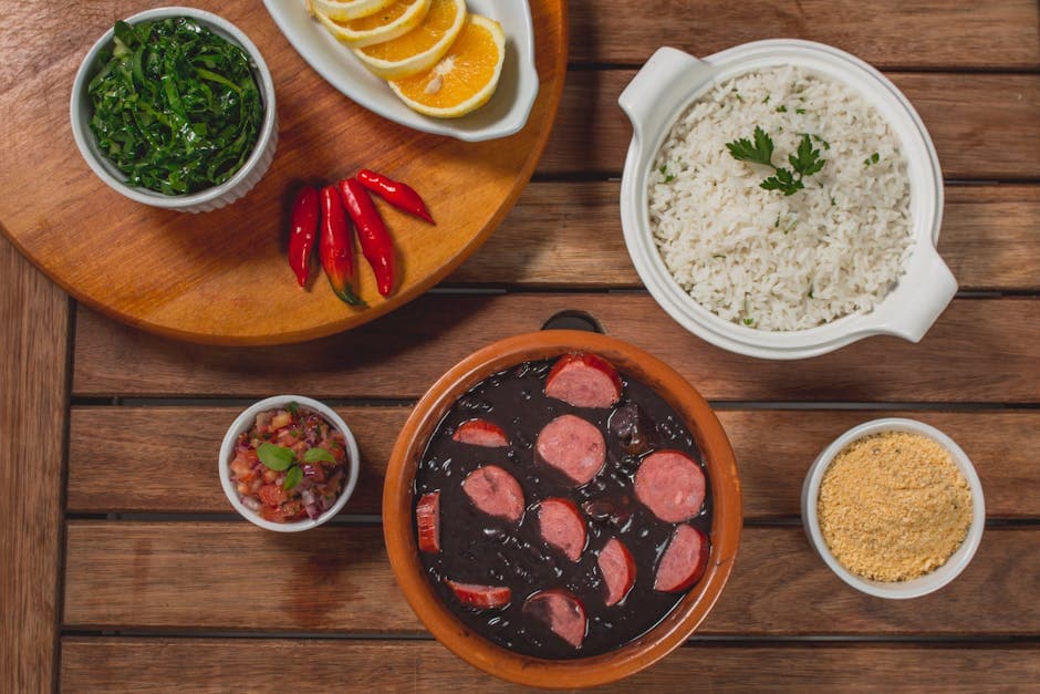 Traditional Brazilian feijoada served with rice, greens, and orange slices, perfect for a hearty meal.