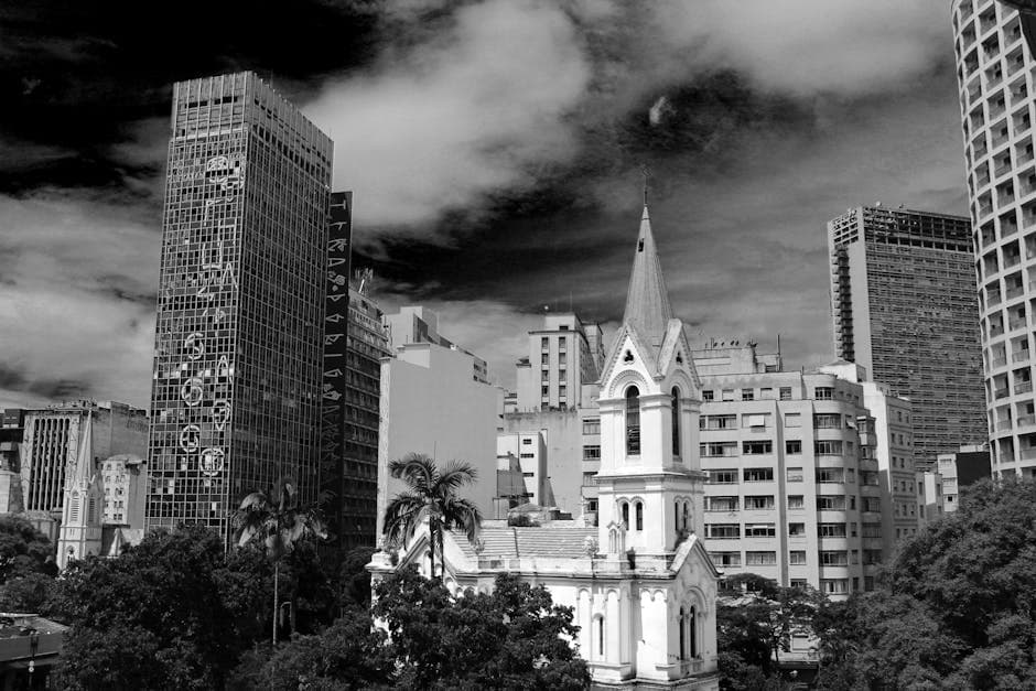 Black and white view of São Paulo's skyline featuring modern skyscrapers and a historic church.