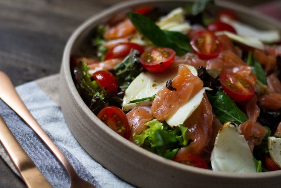 A vibrant salad featuring cherry tomatoes, cheese slices, and fresh greens.