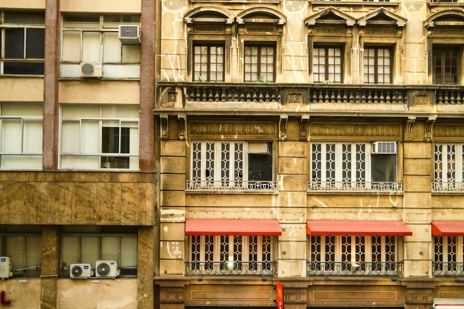 A detailed view of historic architecture with ornate windows and red awnings in São Paulo, Brazil.